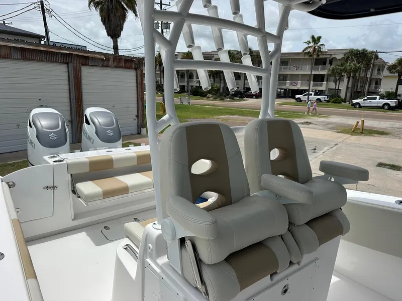 Slide: The Image of 2023 Cape Horn 32xs boat interior with dual seats and Suzuki engines in a coastal setting. - 6