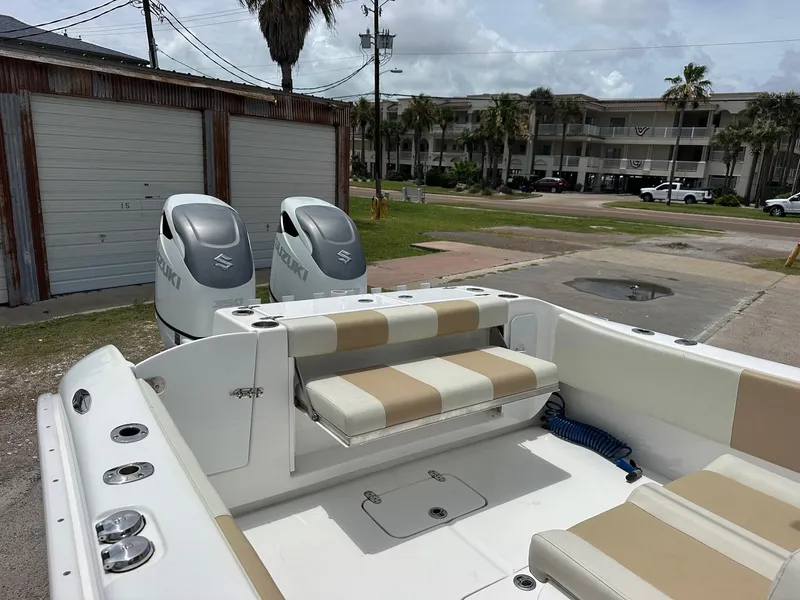 Slide: The Image of 2023 Cape Horn 32xs boat with Suzuki engines, beige seating, and coastal background. - 7