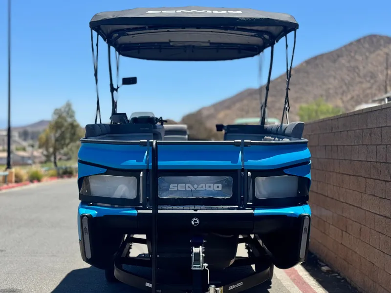 Slide: The Image of 2023 Sea-Doo Switch Cruise 21 pontoon boat parked on a sunny day. - 2