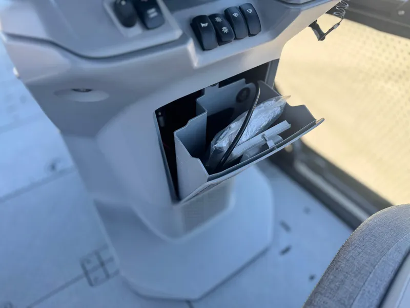 Slide: The Image of 2023 Sea-Doo Switch Cruise 21 dashboard storage compartment with controls and accessories. - 23