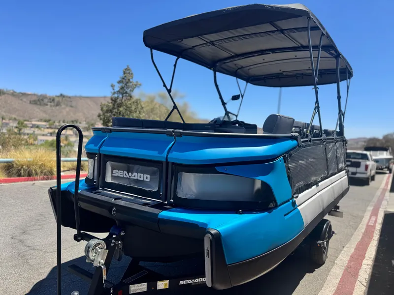 Slide: The Image of 2023 Sea-Doo Switch Cruise 21 pontoon boat with canopy, parked on a sunny day. - 3