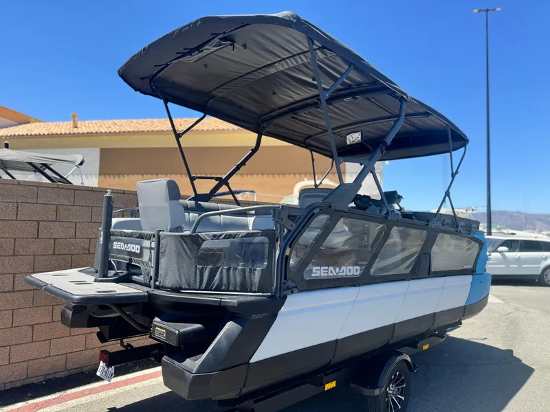 Slide: The Image of 2023 Sea-Doo Switch Cruise 21 pontoon boat with canopy, parked outdoors. - 6