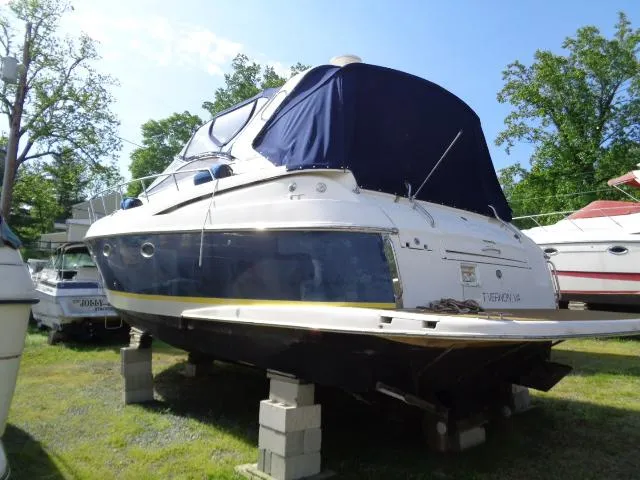 Slide: The Image of 2003 Regal Commodore 3860 yacht on blocks, blue cover, outdoor storage. - 2