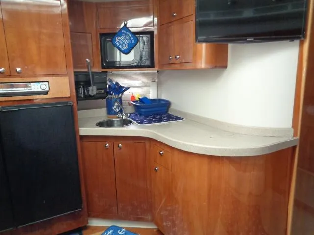 Slide: The Image of 2003 Regal Commodore 3860 yacht kitchen with wooden cabinets, microwave, and countertop. - 23