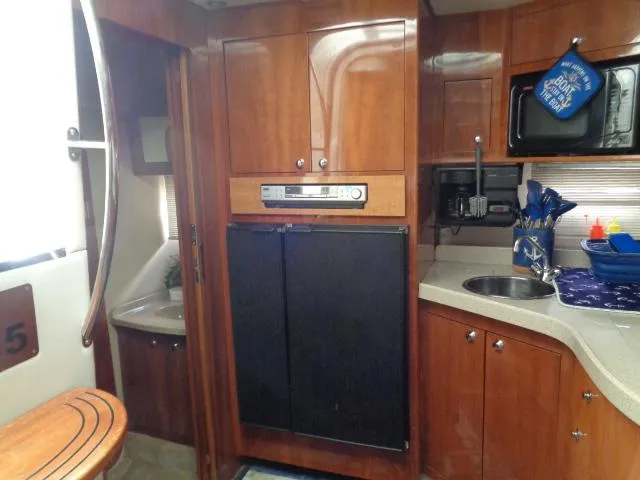 Slide: The Image of 2003 Regal Commodore 3860 yacht kitchen with wood cabinets, sink, and appliances. - 24