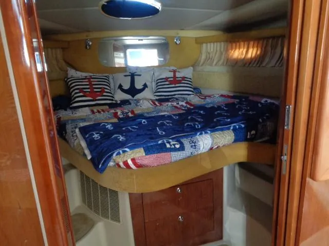 Slide: The Image of Cozy cabin interior of 2003 Regal Commodore 3860 with nautical-themed bedding. - 27