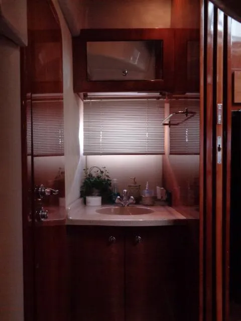 Slide: The Image of 2003 Regal Commodore 3860 yacht bathroom with wooden cabinetry and sink. - 31