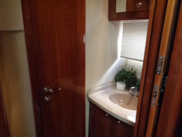 Slide: The Image of 2003 Regal Commodore 3860 yacht bathroom with wooden cabinetry and compact sink. - 32