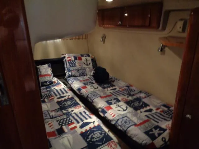 Slide: The Image of 2003 Regal Commodore 3860 cabin with nautical-themed twin beds and wooden cabinetry. - 35