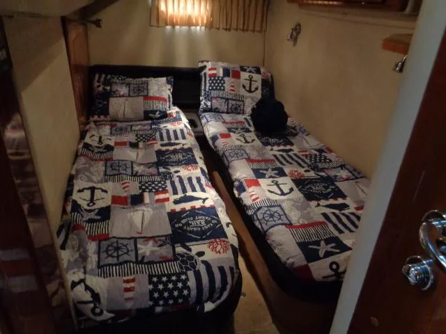 Slide: The Image of Twin beds with nautical-themed bedding in a 2003 Regal Commodore 3860 cabin. - 36