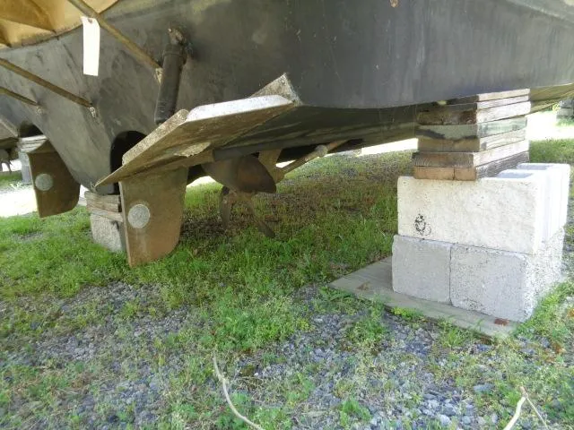 Slide: The Image of 2003 Regal Commodore 3860 boat hull on blocks, showing propeller and rudder. - 44