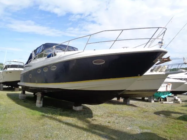Slide: The Image of 2003 Regal Commodore 3860 yacht on land, blue hull, sunny day. - 5