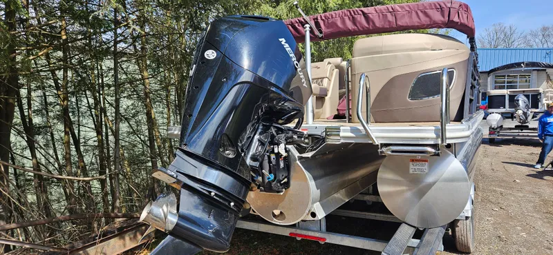 Slide: The Image of 2022 Bennington LX 23 Quad Bench pontoon boat with Mercury outboard motor on a trailer. - 6