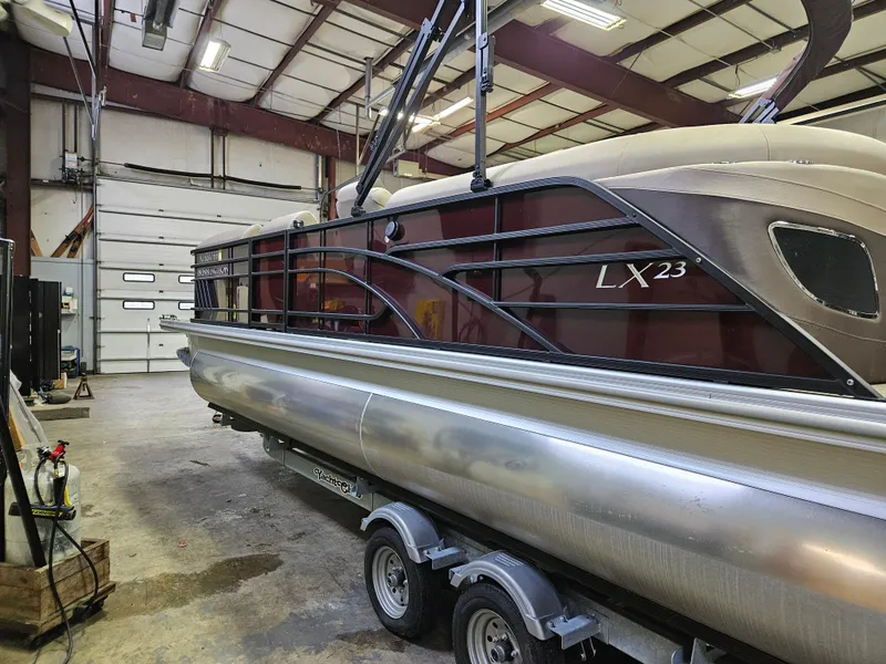 Slide: The Image of 2022 Bennington LX 23 Quad Bench pontoon boat in a warehouse setting. - 8