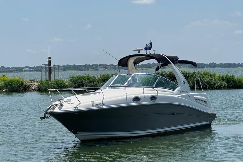 Slide: The Image of 2006 Sea Ray 260 Sundancer boat on calm water with scenic background. - 1