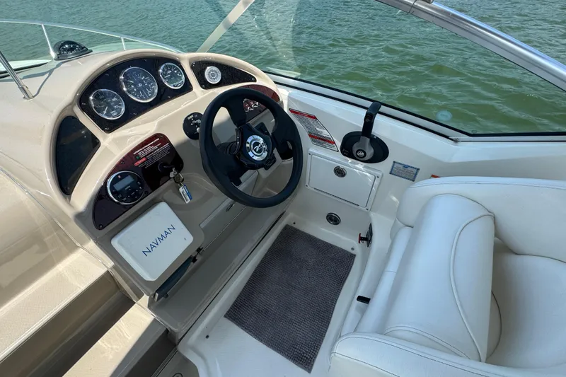 Slide: The Image of 2006 Sea Ray 260 Sundancer helm with steering wheel, gauges, and Navman system. - 11