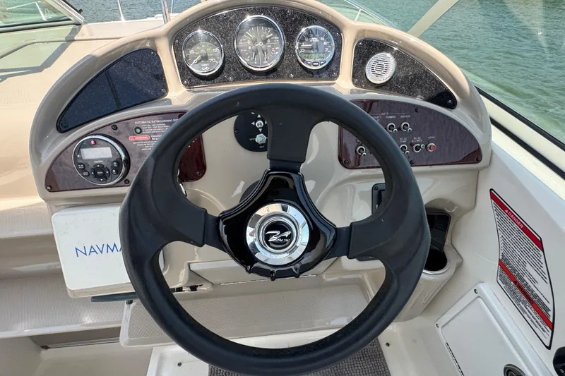 Slide: The Image of Steering wheel and dashboard of a 2006 Sea Ray 260 Sundancer boat. - 12