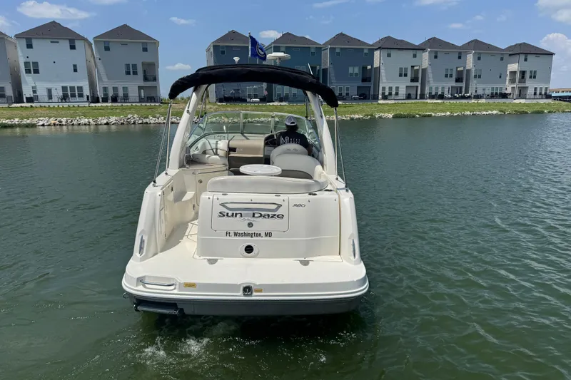 Slide: The Image of 2006 Sea Ray 260 Sundancer boat on water near waterfront homes. - 2