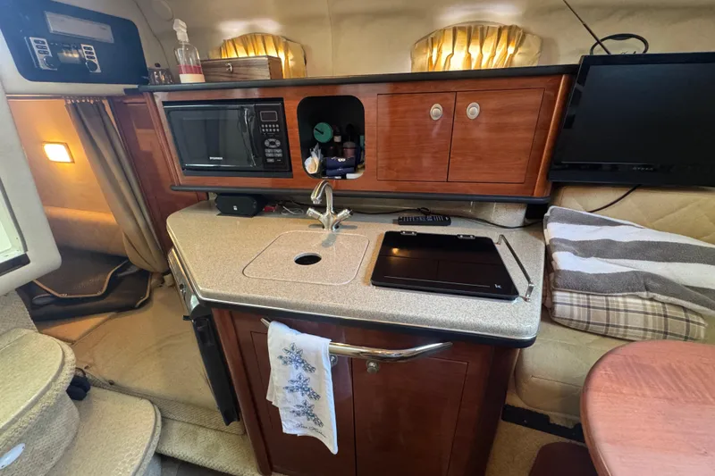 Slide: The Image of 2006 Sea Ray 260 Sundancer cabin with kitchenette, microwave, and cozy seating area. - 22