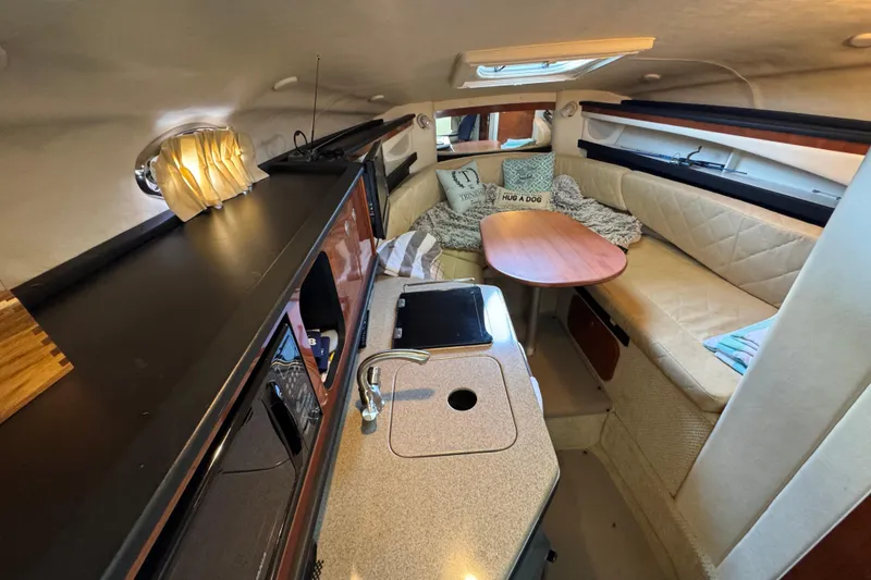 Slide: The Image of Interior of 2006 Sea Ray 260 Sundancer boat with cozy seating and kitchenette. - 23