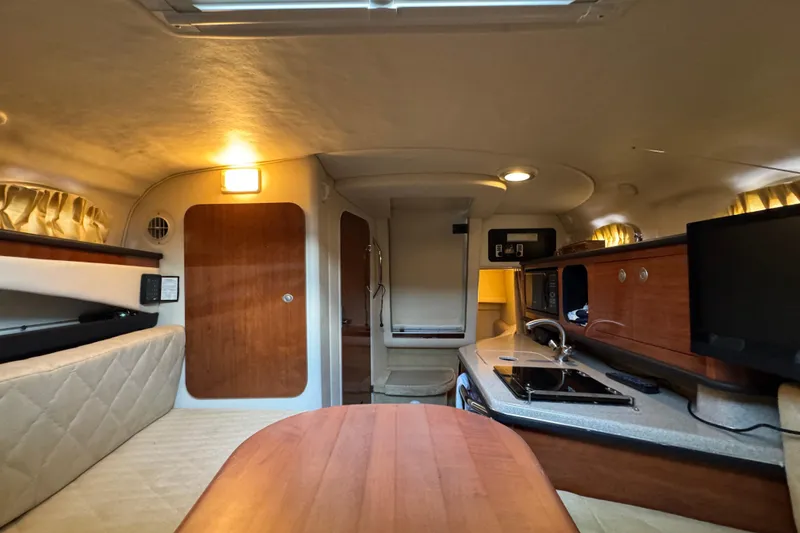 Slide: The Image of Interior of 2006 Sea Ray 260 Sundancer boat, featuring cozy cabin and kitchenette. - 25