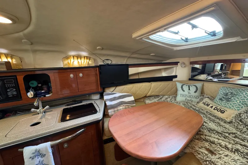 Slide: The Image of Interior of 2006 Sea Ray 260 Sundancer with cozy seating, table, and kitchenette. - 26