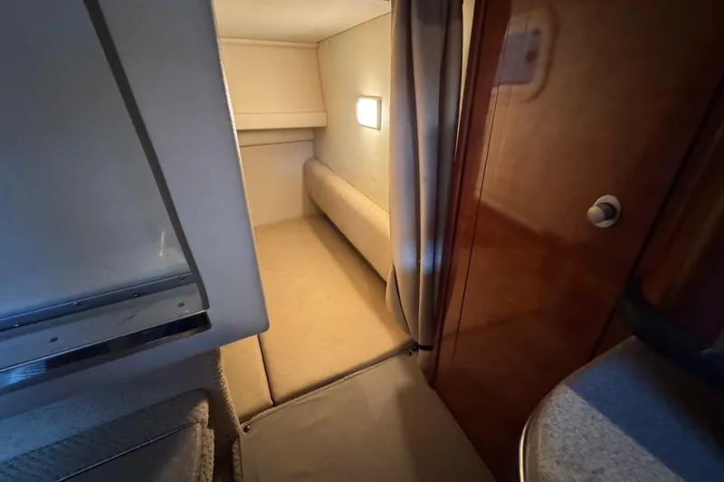 Slide: The Image of 2006 Sea Ray 260 Sundancer cabin interior with cozy sleeping area and soft lighting. - 34