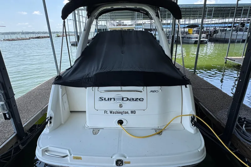 Slide: The Image of 2006 Sea Ray 260 Sundancer docked, covered, with "Sun Daze" name visible. - 38