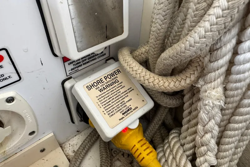 Slide: The Image of Shore power connection on 2006 Sea Ray 260 Sundancer with warning label and coiled ropes. - 40