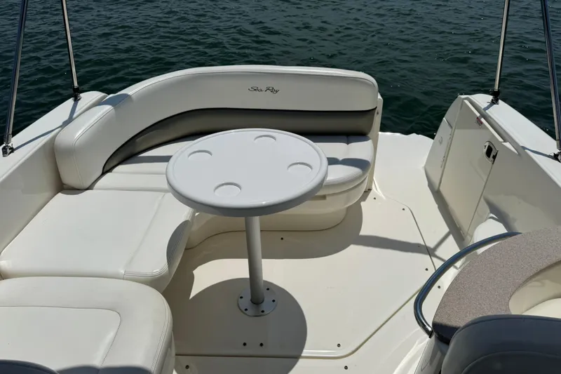 Slide: The Image of 2006 Sea Ray 260 Sundancer boat interior with seating and table on water. - 9