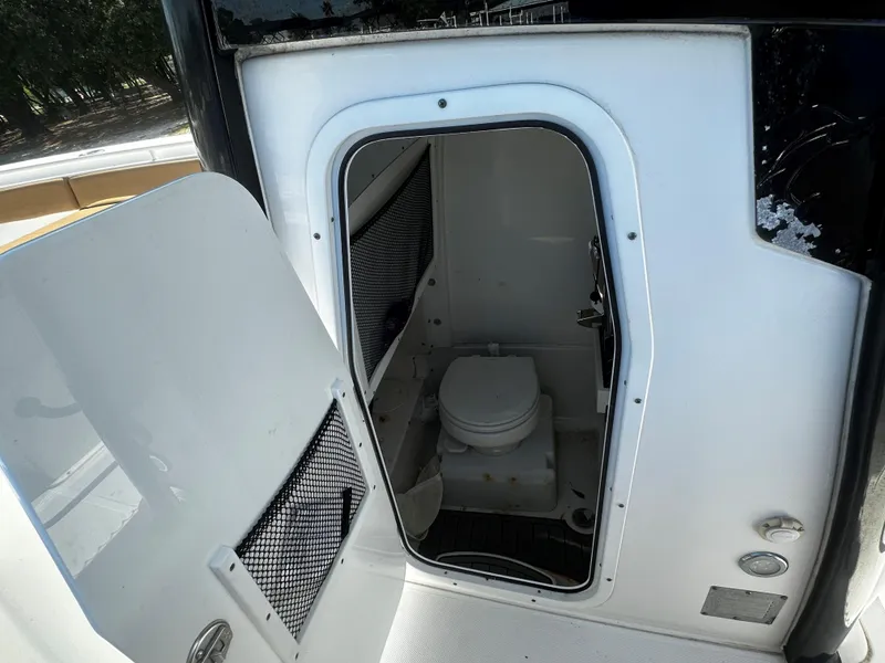 Slide: The Image of 2020 Sea Hunt Gamefish 27 Coffin Box boat interior with open door revealing compact toilet. - 13