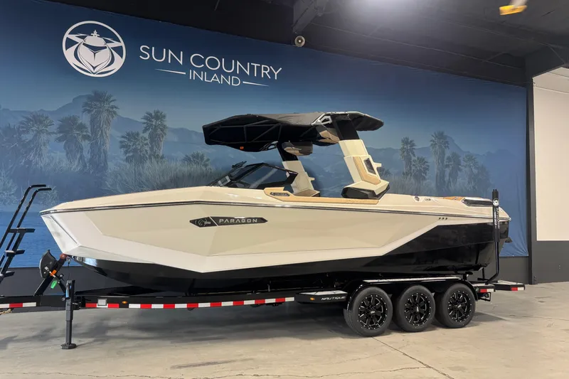 The Image of 2026 Nautique Super Air Nautique G25 Paragon boat displayed indoors on a trailer. - 0