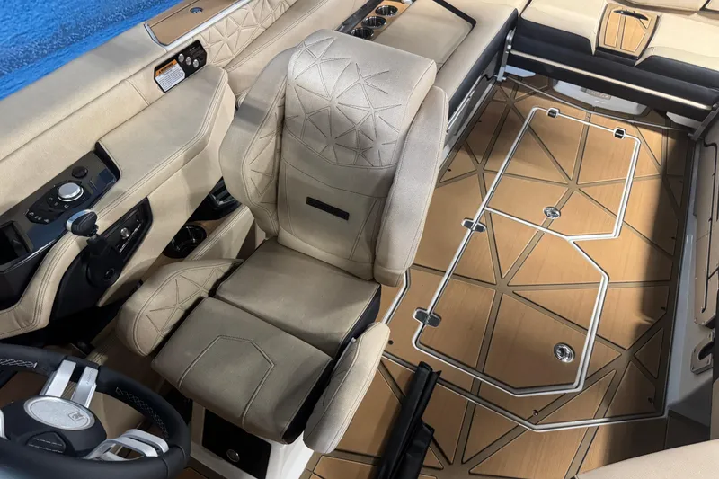 Slide: The Image of 2026 Nautique Super Air Nautique G25 Paragon interior with beige seating and geometric flooring. - 12