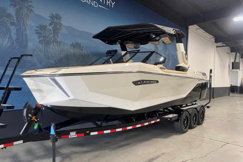 Slide: The Image of 2026 Nautique Super Air Nautique G25 Paragon boat on trailer in showroom. - 2