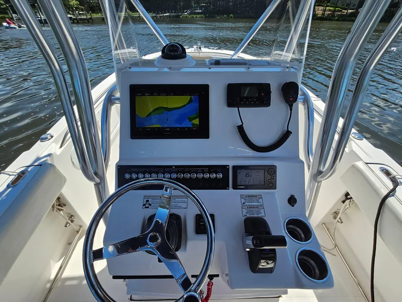 Slide: The Image of Edgewater 228CC 2016 boat console with navigation screen and controls on a sunny day. - 12