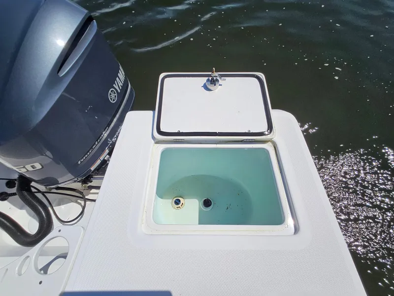 Slide: The Image of Open livewell on 2016 Edgewater 228CC boat with Yamaha outboard motor, floating on water. - 23