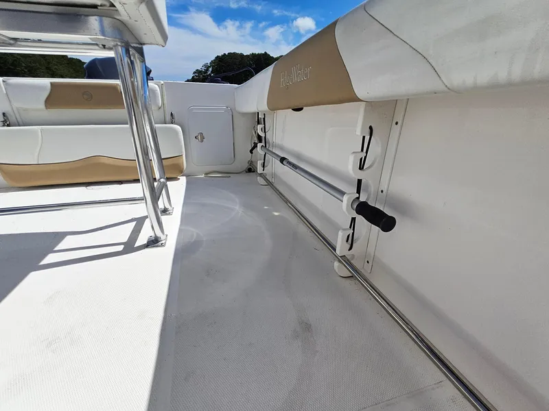 Slide: The Image of 2016 Edgewater 228CC boat interior with rod holders and seating, under a clear blue sky. - 24