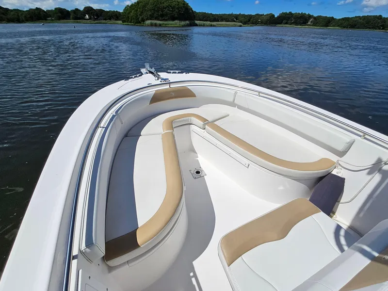 Slide: The Image of 2016 Edgewater 228CC boat with beige seating on a calm lake. - 6