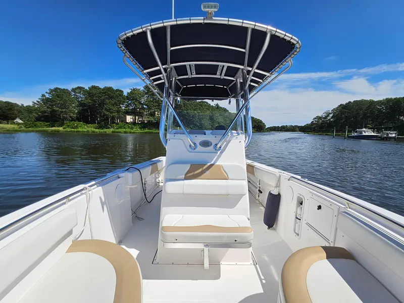 Slide: The Image of 2016 Edgewater 228CC boat on calm water, featuring a sleek design and spacious seating. - 8