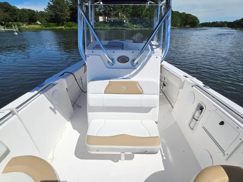 Slide: The Image of 2016 Edgewater 228CC boat interior with seating, on a calm river. - 9