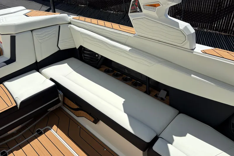 Slide: The Image of Luxurious seating on 2026 Nautique Super Air Nautique G25 boat, featuring sleek design and cup holders. - 12