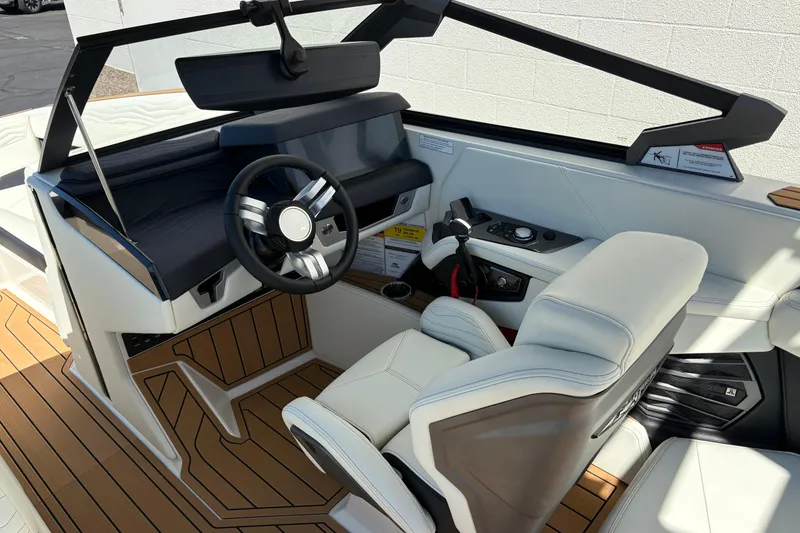 Slide: The Image of 2026 Nautique Super Air Nautique G25 boat interior with modern steering and seating. - 14