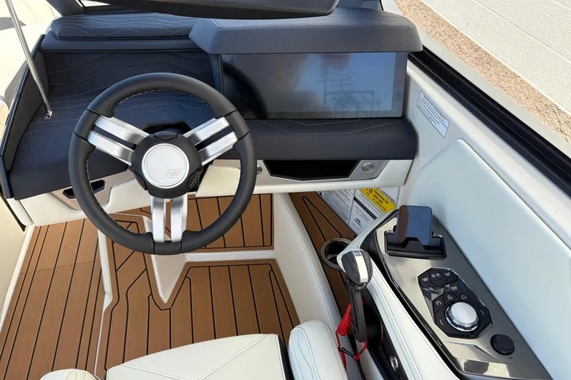 Slide: The Image of 2026 Nautique Super Air Nautique G25 helm with modern steering and control panel. - 16