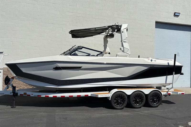 The Image of 2026 Nautique Super Air Nautique G25 boat on trailer, sleek design, parked outdoors. - 5