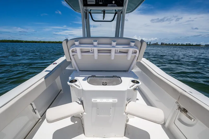 Slide: The Image of 2024 Sea Hunt Ultra 239 SE boat interior with seating and rod holders on open water. - 17