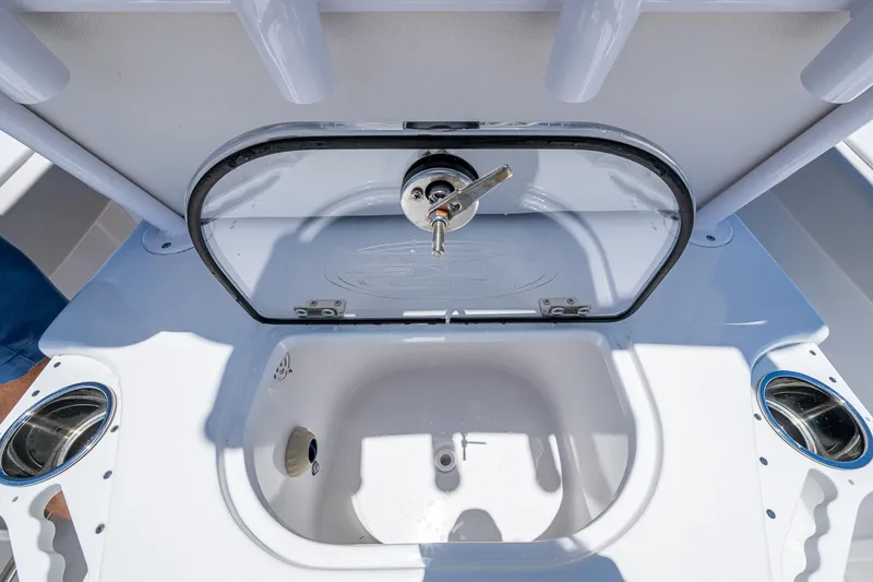 Slide: The Image of Livewell on 2024 Sea Hunt Ultra 239 SE boat, featuring a secure lid and cup holders. - 20