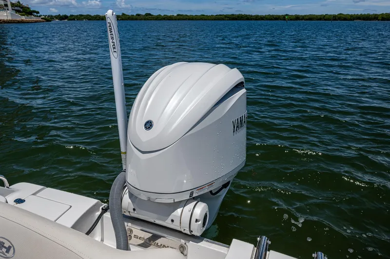 Slide: The Image of 2024 Sea Hunt Ultra 239 SE boat with Yamaha outboard motor on a calm lake. - 22