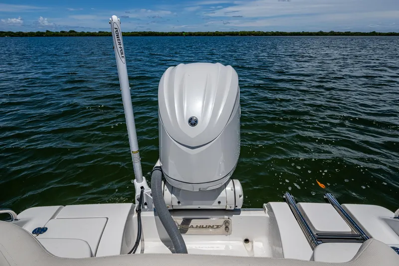 Slide: The Image of 2024 Sea Hunt Ultra 239 SE boat with outboard motor on calm water. - 23