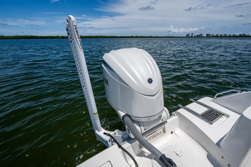 Slide: The Image of 2024 Sea Hunt Ultra 239 SE boat with Yamaha outboard motor on calm water. - 24
