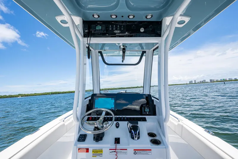 Slide: The Image of 2024 Sea Hunt Ultra 239 SE boat console with steering wheel and navigation system on open water. - 28